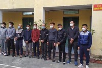 Đối tượng cầm đầu Nguyễn Xuân Tiến (đứng thứ 3, từ phải sang) cùng 9 đối tượng khác tại cơ quan công an. (Ảnh: TTXVN phát).