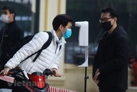 Học sinh được đo thân nhiệt và khử khuẩn tại khu vực cổng trường trước khi lên lớp. (Ảnh: Hoài Nam/Vietnam+)