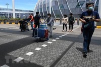 Hành khách đeo khẩu trang phòng dịch COVID-19 tại sân bay quốc tế Changi, Singapore. (Ảnh: AFP/TTXVN).