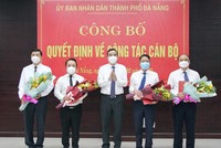 Ông Lê Trung Chinh (giữa), Chủ tịch UBND thành phố Đà Nẵng trao Quyết định và tặng hoa chúc mừng các cán bộ được điều động, bổ nhiệm vị trí công tác mới.