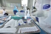 Nhân viên y tế lấy mẫu xét nghiệm cho người dân. (Ảnh: Minh Quyết/TTXVN).