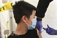 Nhân viên y tế tiêm vaccine phòng COVID-19 cho trẻ em. (Ảnh: AFP/TTXVN).