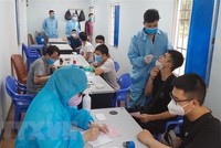 Mọi người ra vào khu vực làm thủ tục xuất nhập khẩu, xuất nhập cảnh tại cửa khẩu quốc tế Móng Cái. (Ảnh: Văn Đức/TTXVN).