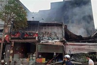 Hiện trường vụ cháy tại địa chỉ ở số 63 Nguyễn Hoàng lan ra nhiều nhà xung quanh. (Ảnh: TTXVN phát).