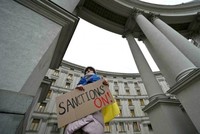 Một người biểu tình ủng hộ các lệnh trừng phạt chống lại Nga đứng bên ngoài Bộ Ngoại giao Ukraine ở Kiev ngày 21/2. Ảnh: AFP.