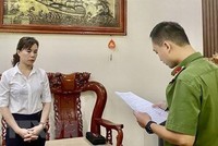 Cán bộ Phòng Cảnh sát điều tra tội phạm về tham nhũng, kinh tế, buôn lậu Công an tỉnh Cao Bằng tống đạt quyết định khởi tố bị can, lệnh bắt bị can để tạm giam đối với bà Hoàng Thị Xuyến, Giám đốc Ban quản lý dự án đầu tư và xây dựng huyện Bảo Lạc. (Ảnh: TTXVN phát).