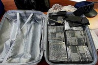 Cơ quan chức năng thu giữ số lượng lớn tiền mệnh giá 100 USD bị nhuộm đen bằng hóa chất. (Ảnh: TTXVN phát)