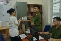 Lực lượng công an cấp biển số xe máy cho người dân đến đăng ký, bấm biển (Ảnh: Hoàng Hiệp).