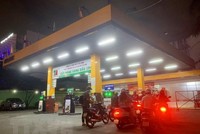 Người dân mua xăng tại Cửa hàng xăng dầu trên đường Hoàng Văn Thụ (quận Phú Nhuận, Thành phố Hồ Chí Minh), tối ngày 12/10. (Ảnh: Hồng Đạt/TTXVN)