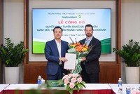 Ông Phạm Quang Dũng, Chủ tịch HĐQT Vietcombank (bên trái) trao quyết định và tặng hoa chúc mừng tân Giám đốc Trung tâm ngân hàng số Vietcombank.