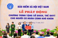 Phó Tổng Giám đốc Vietcombank Nguyễn Việt Cường (hàng đầu, bên trái) trao biểu trưng tặng 1.000 sổ BHXH, 9.968 thẻ BHYT với tổng trị giá 5 tỷ đồng cho đại diện BHXH Việt Nam.