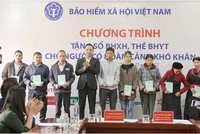 Phó Chủ tịch chuyên trách HĐQL BHXH Nguyễn Văn Cường trao tặng sổ BHXH, thẻ BHYT tới người dân.