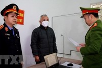 Cơ quan chức năng tiến hành tống đạt quyết định khởi tố, bắt tạm giam đối với bị can Phan Văn Nhâm (giữa), Chi Cục trưởng Chi cục Hải quan Cửa khẩu quốc tế Nậm Cắn về hành vi nhận hối lộ. (Ảnh: TTXVN phát)