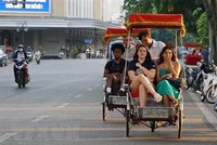 Du khách trải nghiệm du lịch quanh hồ Hoàn Kiếm bằng xíchlô. (Ảnh: Khánh Hòa/TTXVN)