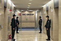 Lực lượng Cảnh sát điều tra làm nhiệm bảo vệ trong quá trình khám xét tại trụ sở Công ty AIC, 69 phố Tuệ Tĩnh, ngày 29/4/2022. (Ảnh: Phạm Kiên/TTXVN).