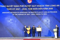 Được sự uỷ quyền của Thủ tướng Chính phủ, Bộ trưởng Bộ Kế hoạch và Đầu tư Nguyễn Chí Dũng (thứ hai từ phải qua) trao Quyết định phê duyệt quy hoạch cho lãnh đạo tỉnh Long An.