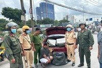 Lực lượng chức năng, Công an thành phố Dĩ An, tỉnh Bình Dương, bắt quả tang đối tượng Võ Đức Quốc Trung vận chuyển cung cấp thuốc lá lậu. (Ảnh: TTXVN phát)