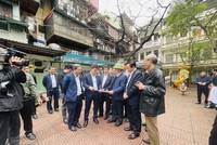 Bí thư Thành ủy Hà Nội Đinh Tiến Dũng trao đổi với các đồng chí lãnh đạo về công tác chỉ đạo, triển khai cải tạo, xây dựng lại chung cư cũ trên địa bàn quận Đống Đa. (Ảnh: Tuyết Mai/TTXVN)