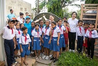 Chị Nguyễn Hồng Hạnh, cán bộ Nước sạch, Vệ sinh môi trường - UNICEF Việt Nam (áo xanh, bên trái) và cán bộ Masterise Group chia sẻ niềm vui với các em học sinh trường Tiểu học Long Phú C khi đón thiết bị nhà vệ sinh không phát thải. Ảnh: UNICEF Việt Nam/Trương Việt Hùng.