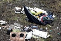 Nhân viên cứu hộ ngồi bên các mảnh vỡ của máy bay. Ảnh: Reuters