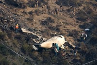 Các nhà điều tra Pakistan kiểm tra hiện trường máy bay rơi hôm qua. Ảnh: AP