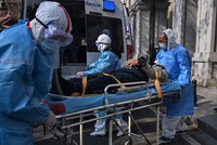 Nhân viên y tế đưa bệnh nhân nghi mắc viêm phổi cấp do virus corona ra khỏi một chung cư tại Vũ Hán, Trung Quốc ngày 30/1. Ảnh: AFP.