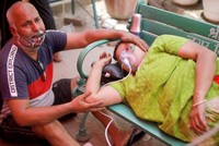 Người dân được hỗ trợ oxy miễn phí do bị khó thở bên ngoài Gurudwara (đền thờ Sikh) trong bối cảnh lây lan dịch bệnh Covid-19 ở Ấn Độ ngày 3/5/2021.