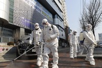 Nhân viên y tế phun thuốc khử trùng trước một nhà thờ ở Daegu, Hàn Quốc. Ảnh: AP.