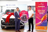 Khách hàng Nguyễn Quốc Đạt (bên phải) nhận giải Đặc biệt ô tô Hyundai Tucson từ chương trình khuyến mại “Đồng Hành Vững Bước” của Hanwha Life Việt Nam