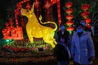 Một gia đình trang chụp ảnh bên cạnh hình tượng con trâu ở thành phố Vũ Hán, Trung Quốc vào ngày 10/2/2021. Ảnh: AFP