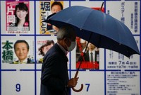 Cử tri di chuyển qua khu vực trưng bày áp phích danh sách các ứng viên cho Hội đồng Thủ đô Tokyo gần điểm bỏ phiếu vào ngày 4/7. Ảnh: Reuters