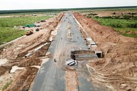 Thi công hoàn thiện tuyến đường chính trong Khu tái định cư Lộc An - Bình Sơn. (Ảnh: Công Phong/TTXVN)