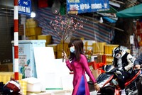 Nhiều người lựa chọn việc đi chụp ảnh chiều ngày 30 tết như một thói quen của bản thân và gia đình, cành đào nhỏ với tà áo dài truyền thống làm cho phố phường sống động hơn hẳn