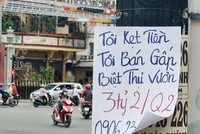 Một tờ rơi rao bán nhà viết tay được dán trước cửa nhà. Ảnh: Lê Toàn 