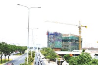 Một dự án nằm ngay mặt tiền đại lộ Đông Tây phải thi công cầm chừng do các vấn đề liên quan đến thủ tục và nguồn vốn. Ảnh: Trọng Tín 