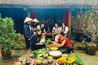 Sinh viên quốc tế trải nghiệm gói bánh chưng trong tour du lịch tại làng cổ Đường Lâm (Hà Nội). Ảnh: Linh Tâm