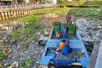 Công nhân môi trường vớt rác trên kênh Nhiêu Lộc - Thị Nghè. Dự án cũng được đầu tư bằng vốn vay Ngân hàng Thế giới - Ảnh: Lê Toàn 
