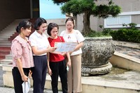 Cán bộ Bảo hiểm xã hội tỉnh tuyên truyền tới người dân về ý nghĩa và lợi ích khi tham gia bảo hiểm y tế hộ gia đình. Ảnh: Dương Chung