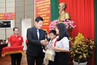 Ông Lâm Bình Vũ trao học bổng và quà cho các em học sinh