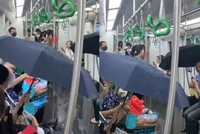 Hành khách che ô khi đi tàu metro Cát Linh - Hà Đông.