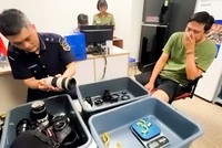 Đối tượng (bên phải) tại cơ quan chức năng.