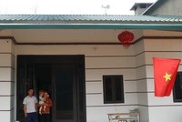 Vợ chồng anh Vàng Sành Guyện ở thôn Nậm Trà, xã Gia Phú, huyện Bảo Thắng, Lào Cai, trong căn nhà mới xây dựng. Ảnh: Hồng Ninh.