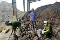 Lực lượng chức năng kiểm tra khu vực chôn lấp chất thải. Ảnh: BCA