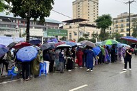 Người dân "đội mưa" xếp hàng nộp hồ sơ mua nhà ở xã hội.