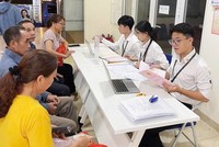 Cán bộ của Trung tâm phục vụ hành chính công Hà Nội hướng dẫn thủ tục cho người dân. Ảnh minh họa.