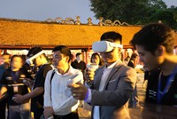 Du khách trải nghiệm công nghệ thực tế ảo tại Văn Miếu - Quốc Tử Giám. Ảnh: Hạnh Phúc.