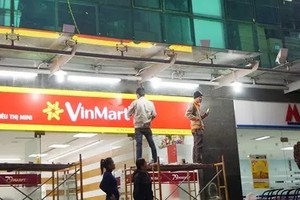 Nhân viên lắp biển Vinmart tại địa điểm siêu thị 79 Market
