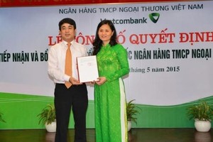 Chủ tịch Hội đồng quản trị Nghiêm Xuân Thành trao quyết định tiếp nhận và bổ nhiệm cho bà Đinh Thị Thái. Nguồn: Vietcombank