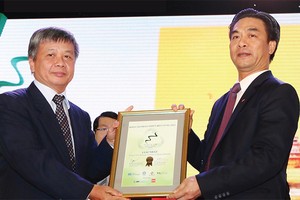 Thứ trưởng Bộ Kế hoạch và Đầu tư Nguyễn Thế Phương (bìa trái) trao giải Báo cáo phát triển bền vững xuất sắc nhất năm 2015 cho ông Phạm Tiến Dũng, Tổng giám đốc PV Drilling