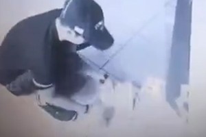 Người đàn ông cúi xuống nhặt tiền rơi ra từ cây ATM. Ảnh: Sun.